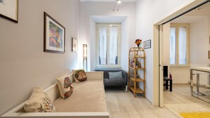 Uma sala de estar moderna com sofá, estante e espaço para refeições.