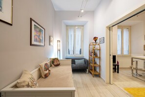 Ein modernes Wohnzimmer mit einer Couch, einem Bücherregal und einem Essbereich.