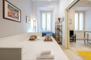 A modern hotel room with a large bed, a wooden side table, a TV, and a balcony with a view. - A 20 Gradini dai Musei Vaticani (Rome)