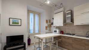 Cozinha moderna com bancada branca, eletrodomésticos de aço inoxidável e armários de madeira.