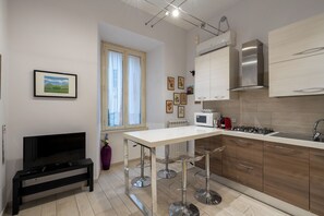 Eine moderne Küche mit weißer Arbeitsplatte, Edelstahlgeräten und Holzschränken.