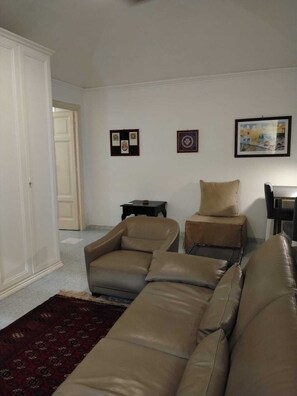 A living room with a sofa set, a rug, and framed pictures on the wall. - La Casetta di Piazza Vittorio (Rome)
