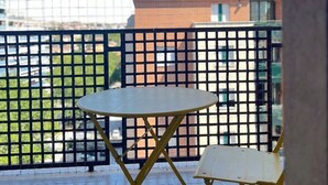 A balcony with a table and chairs, a view of buildings, and a clear sky. - Tentazioni Raffinate - Luxury Suite (Perugia)