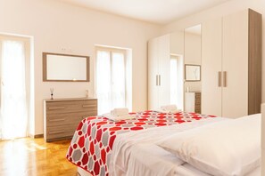 Un dormitorio con cama, cómoda, espejo y armario.