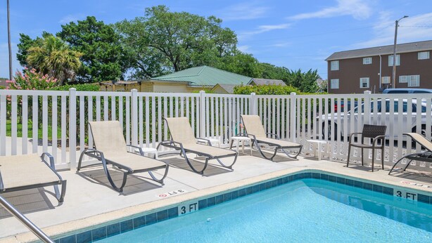 A swimming pool with lounge chairs and a white fence. - Walk to the Beach 2 BR Condo with a Shared Pool! Colony III 201 (Surfside Beach)