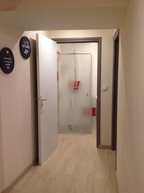 A hallway with a door leading to a room, a wall-mounted sign, and a light switch. - Apartment 'La Maison Des Bains De César' with Mountain View and Wi-Fi (Mont-Dore)