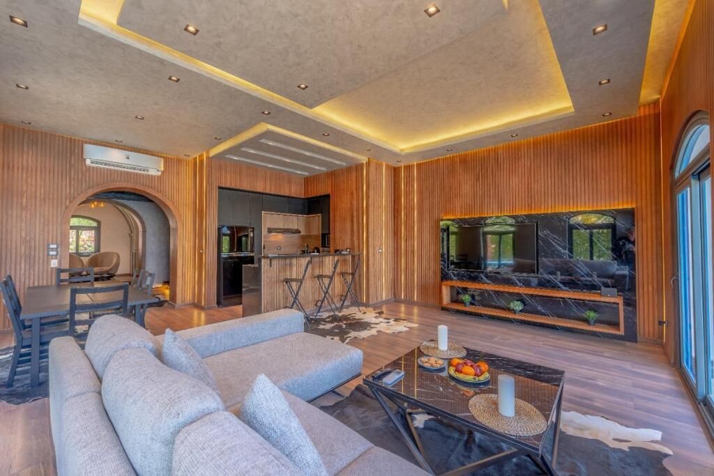 Ein modernes Wohnzimmer mit einer Couch, einem Couchtisch und einem Fernseher.