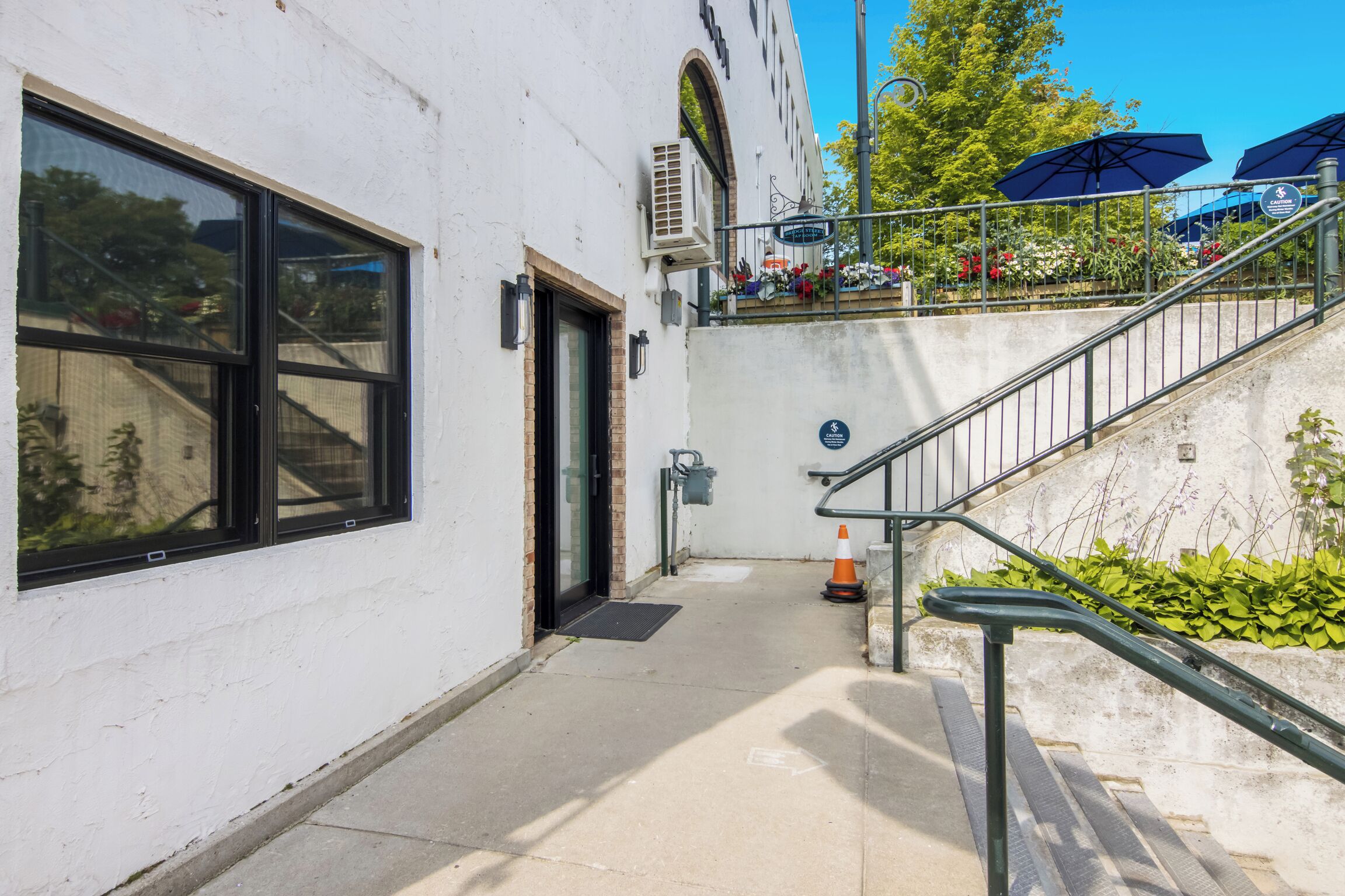 Un bâtiment doté d’un escalier menant à un étage supérieur, d’une porte et d’une fenêtre.