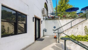 Ein Gebäude mit einer Treppe, die zu einer oberen Ebene führt, einer Tür und einem Fenster.