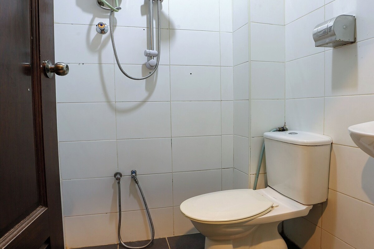 Un baño con inodoro, ducha y secamanos.