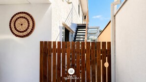 A gated entrance with a wooden fence and a circular mosaic wall. - Loft Campeche 500mt da Praia - Floripa (Florianópolis)