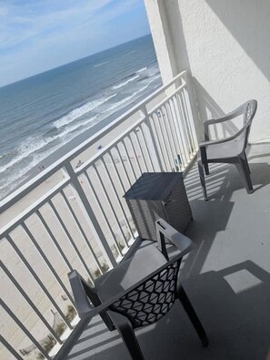 A balcony with two chairs and a table, overlooking the ocean. - Sea Mist 20907 Newly Renovated Oceanfront Studio (Myrtle Beach)