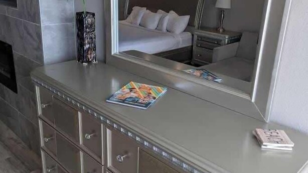 A bathroom vanity with a mirror, a magazine, and a vase with flowers. - Sea Mist 20907 Newly Renovated Oceanfront Studio (Myrtle Beach)