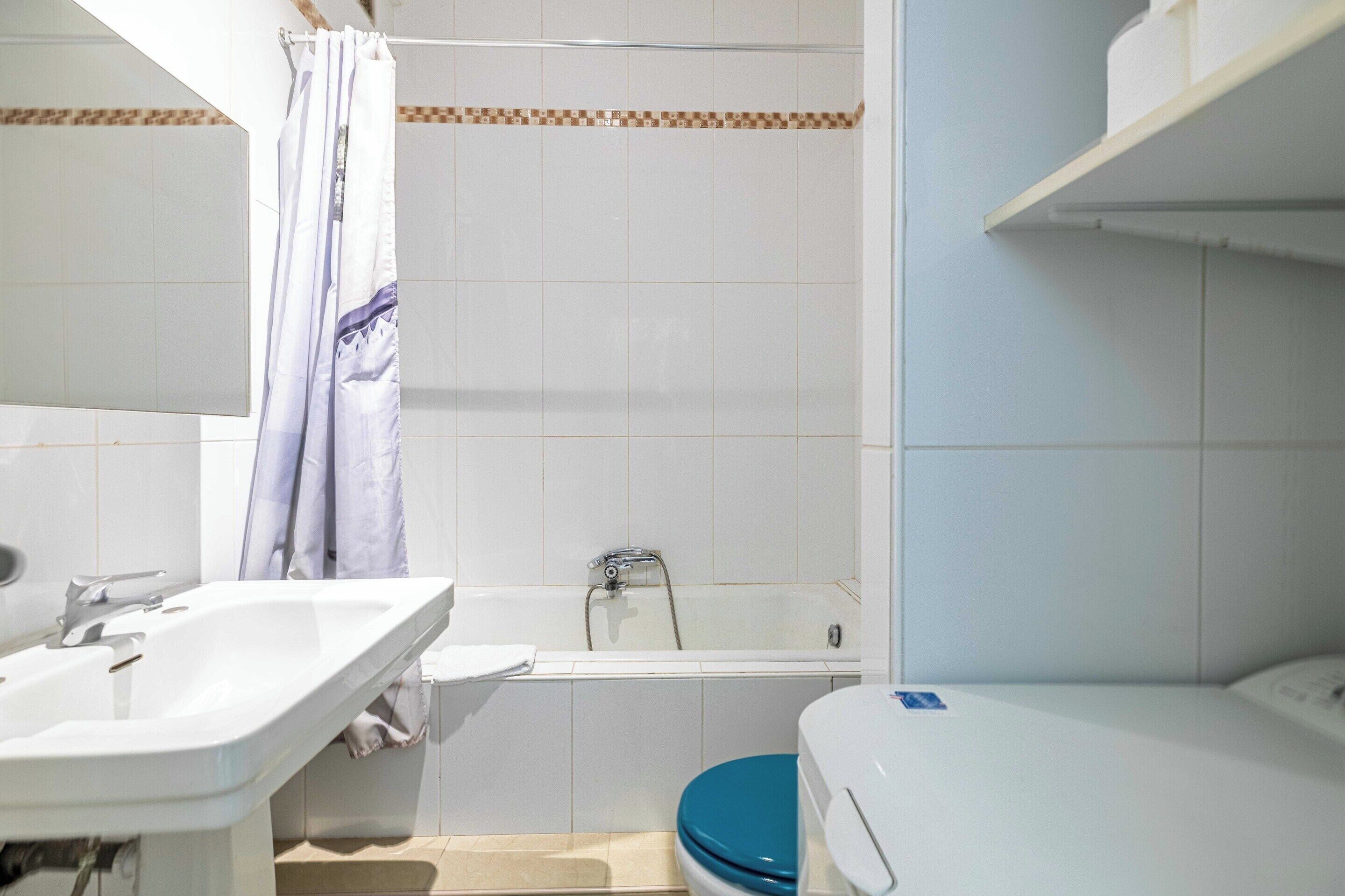 Baño con ducha, lavabo e inodoro.