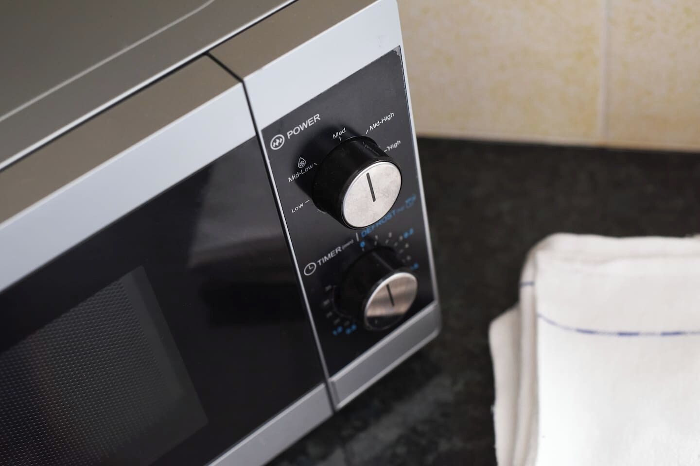 A microwave with a power dial and timer settings.