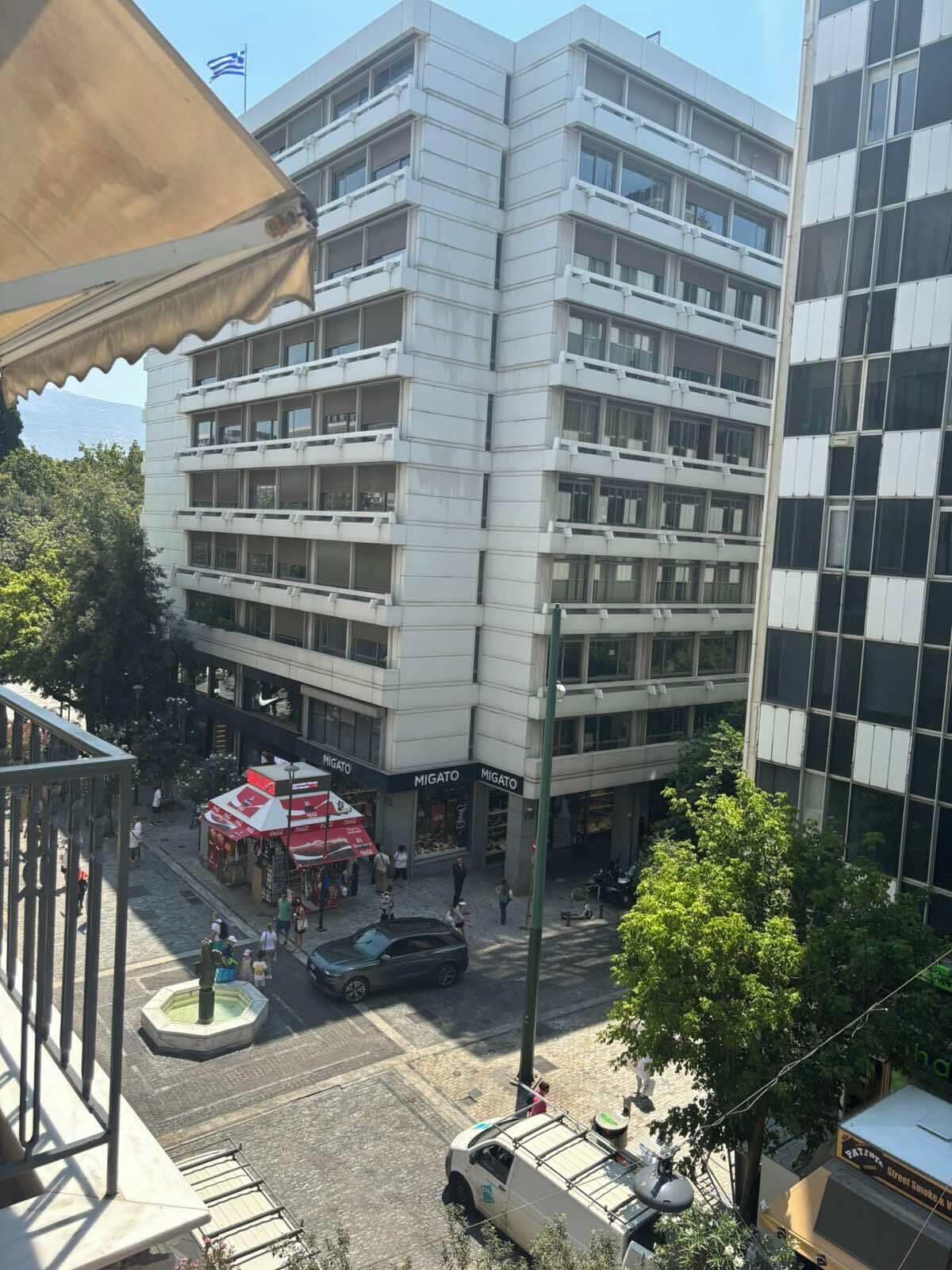 Un edificio de varios pisos con una planta baja comercial que alberga una tienda llamada 'MIGATO'.