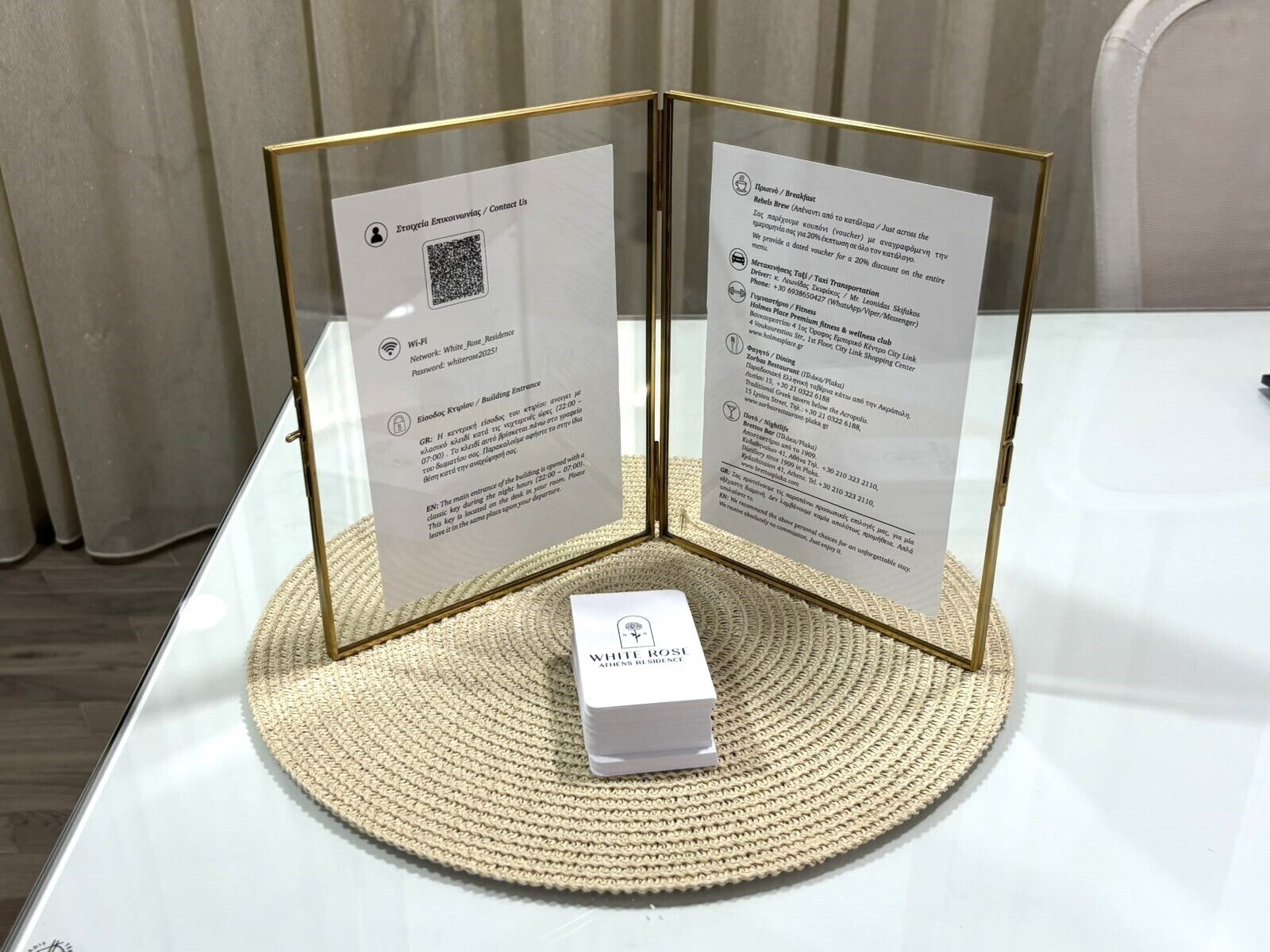 A display with two informational panels and a small white box labeled 'WHIT ROSE RESIDENCE' on a woven mat.