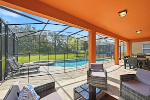 A covered outdoor area with a pool, seating, and a view of the surrounding landscape. - Modern 6BRPoolVilla w/HotTub &GameRoom Near Disney (Kissimmee)