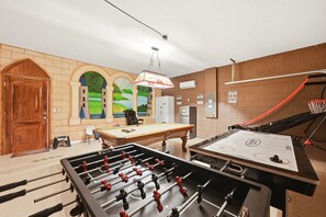 A room with a foosball table, a pool table, and a basketball hoop. - Modern 6BRPoolVilla w/HotTub &GameRoom Near Disney (Kissimmee)