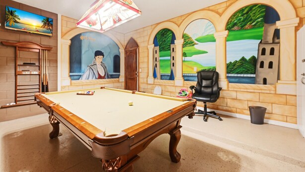 A room with a pool table, a chair, and a mural of a castle. - Modern 6BRPoolVilla w/HotTub &GameRoom Near Disney (Kissimmee)