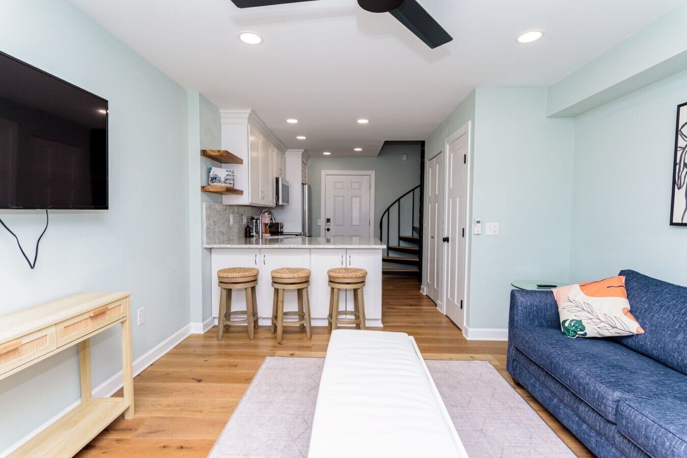 Un espacio habitable moderno con cocina, comedor y zona de estar con sofá y televisión.