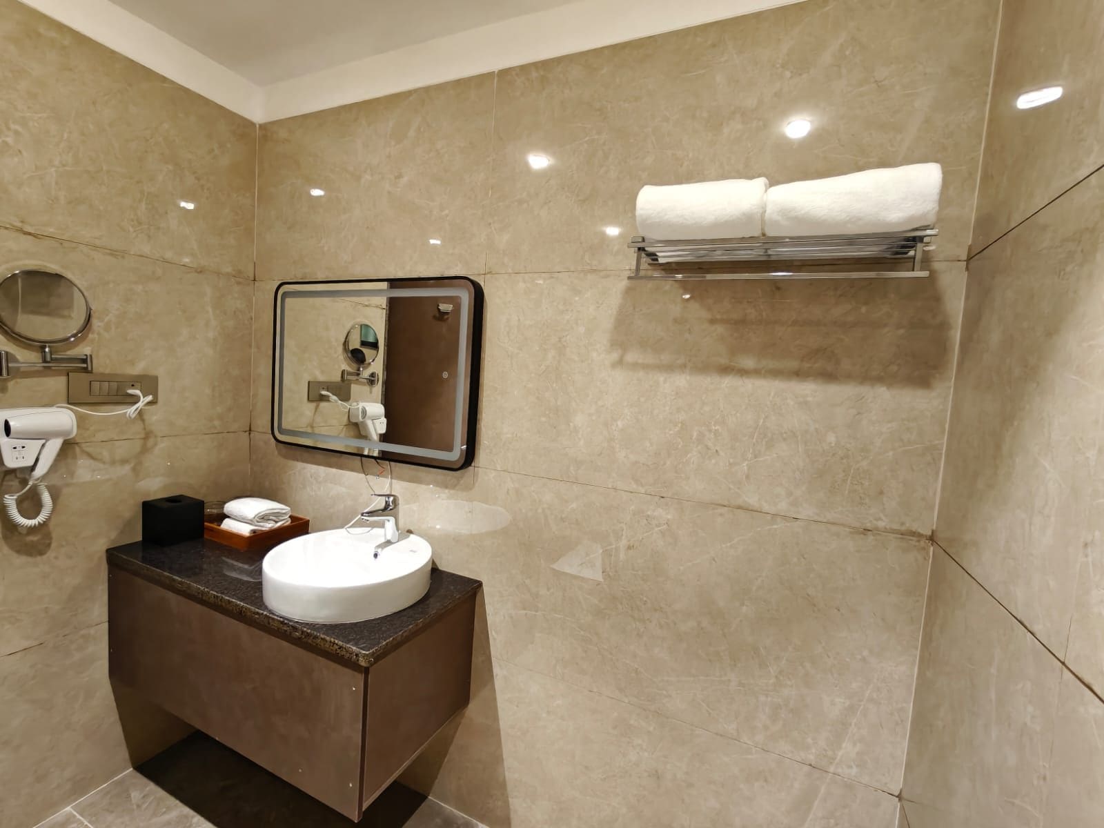 A bathroom with a sink, mirror, towel rack, and hair dryer.