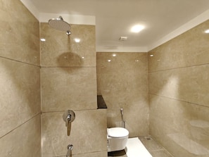 Un baño moderno con ducha, inodoro y tocador.