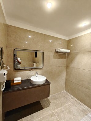A bathroom with a sink, mirror, and towel rack. - Enrise By Sayaji Gandhidham (Gandhidham)