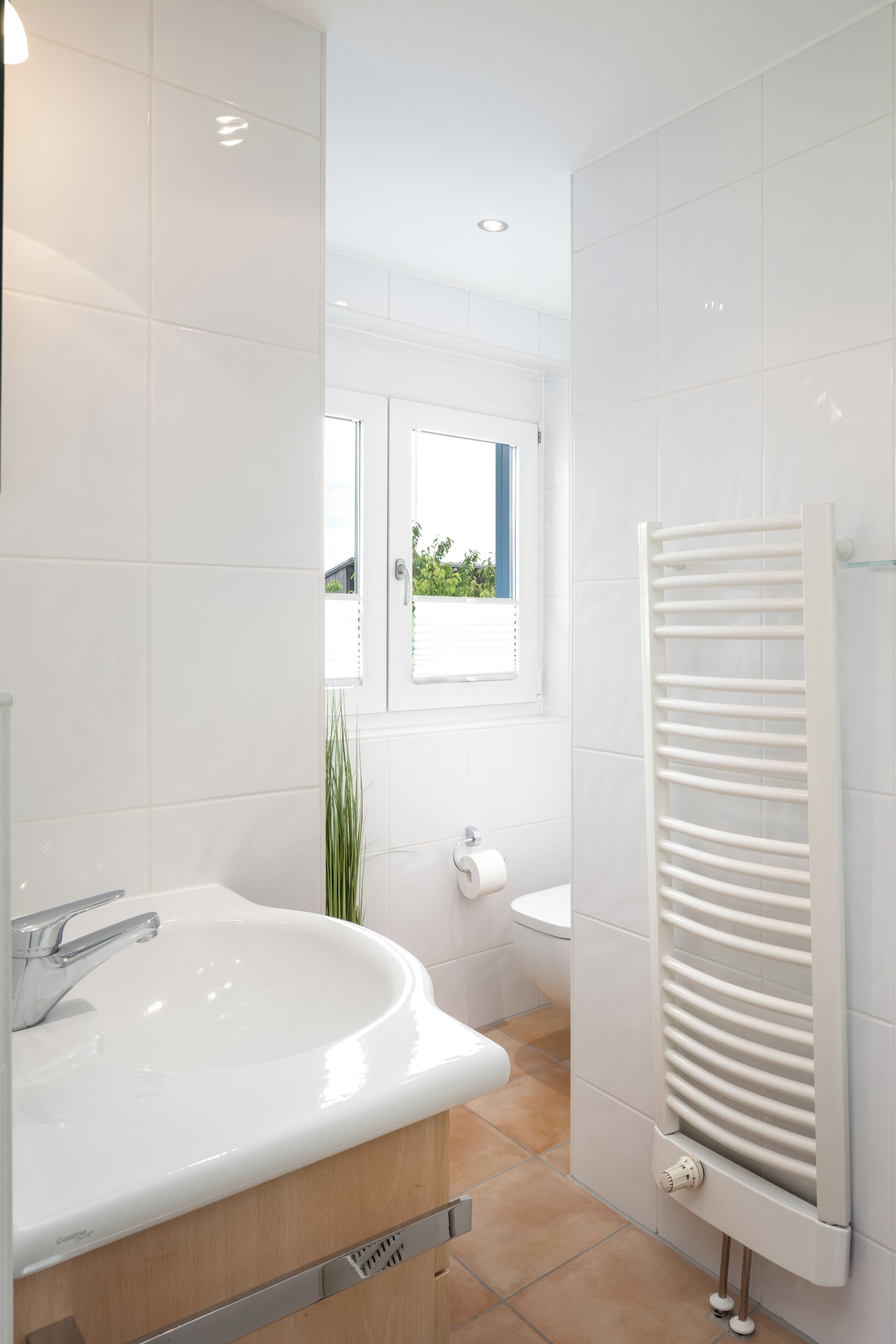 Une salle de bain moderne avec un lavabo blanc, des toilettes et un espace douche.