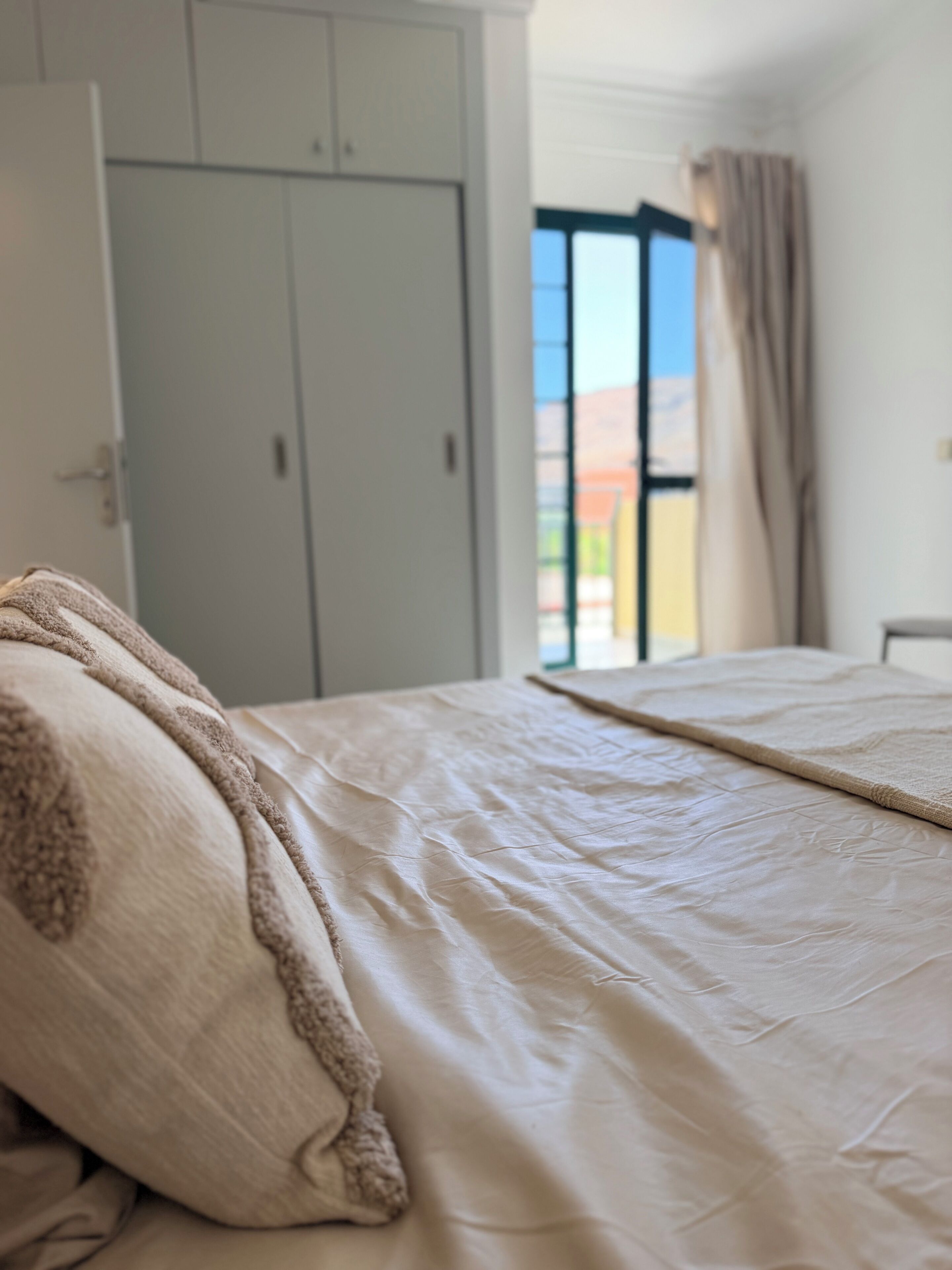 Une chambre à coucher avec un lit, une armoire et une vue sur l’extérieur.