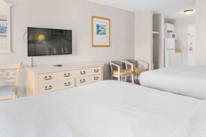 A hotel room with two beds, a TV, a dresser, and a chair. - Sea Mist 51112 Ocean View Vacation Rental (Myrtle Beach)