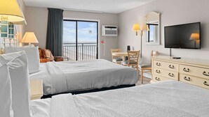 A hotel room with two beds, a desk, a chair, a dresser, a TV, and a balcony with a view. - Sea Mist 51112 Ocean View Vacation Rental (Myrtle Beach)