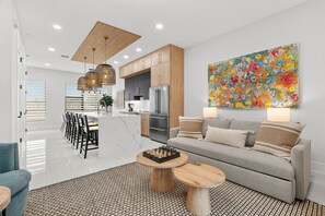 A modern living room with a sofa, coffee table, and a chessboard. - Papaya Place 2 Bedroom Townhouse (Sarasota)