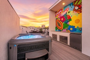 A rooftop terrace with a hot tub, outdoor seating, and a colorful mural. - Papaya Place 2 Bedroom Townhouse (Sarasota)