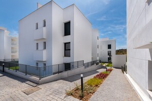 A modern building with a flat facade, multiple windows, and a gated entrance. - 13 - Modern 2BR near Cala de Mijas (La Cala de Mijas)