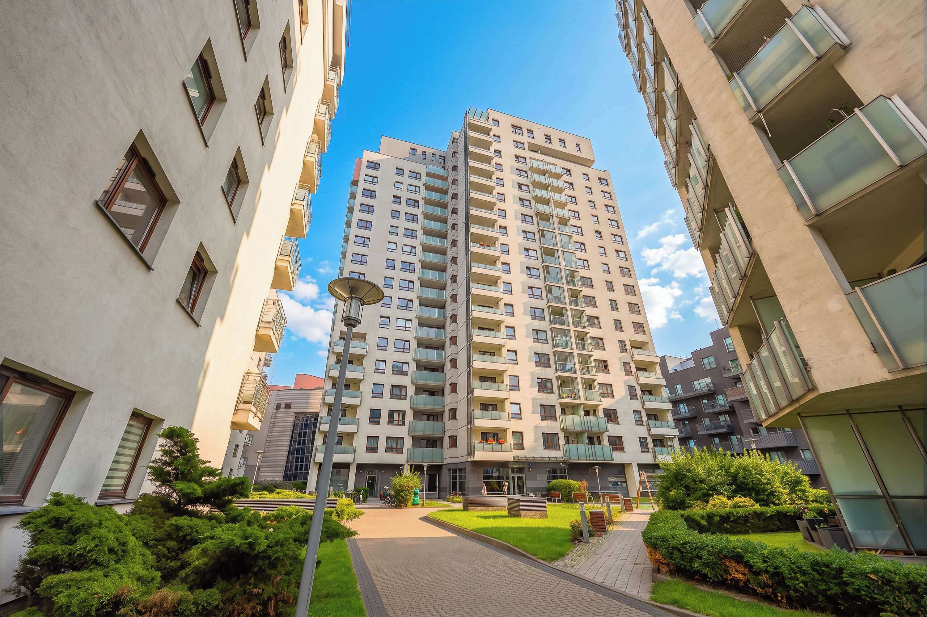 An exterior view of the residential complex surrounded by greenery. The modern design creates a welcoming first impression.