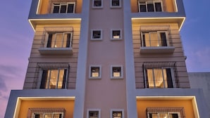 Un hôtel dont la façade porte une enseigne indiquant « OnlyStay Hotel » et « Corporate Suites ».