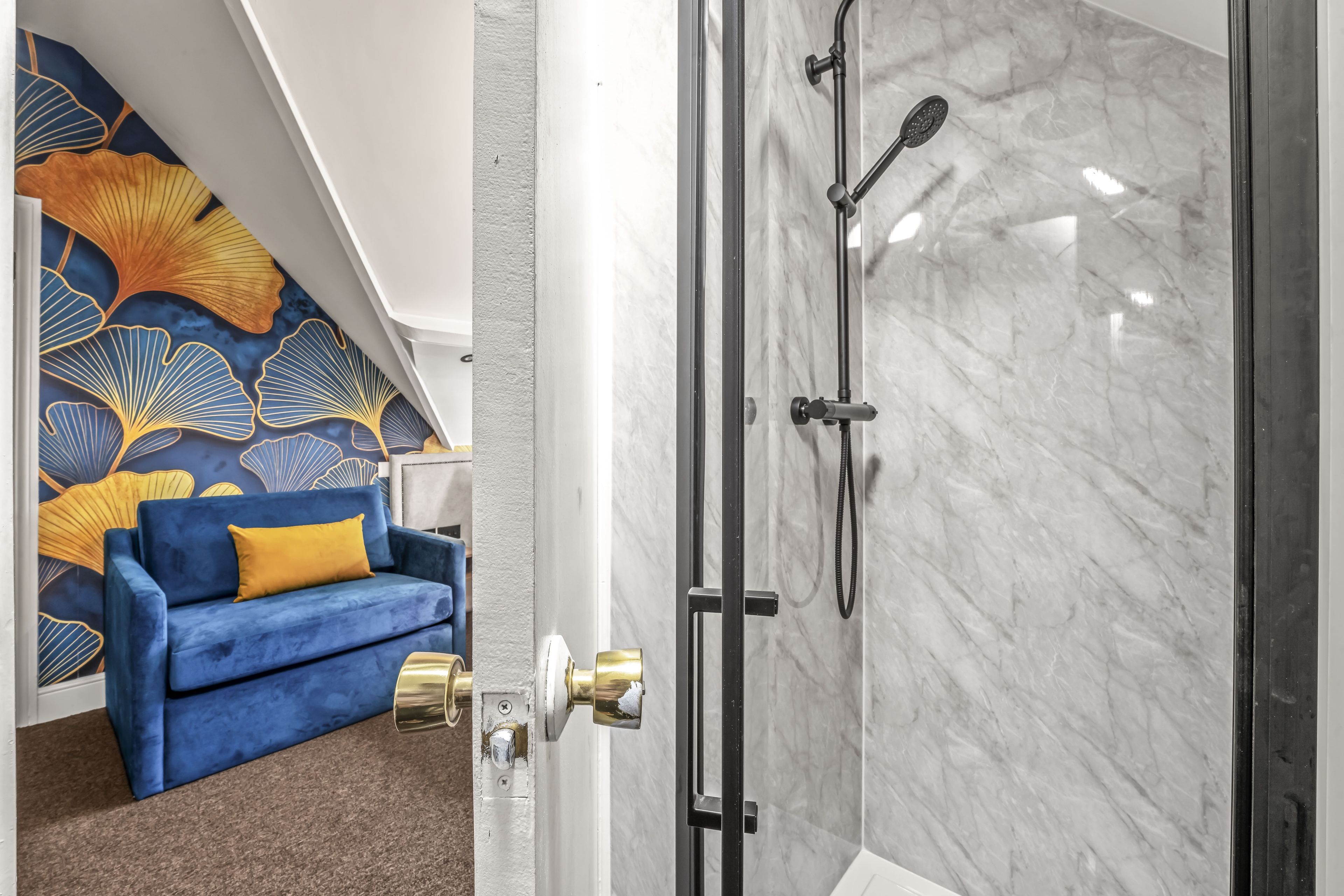 Un baño moderno con cabina de ducha de vidrio y pared de mármol.