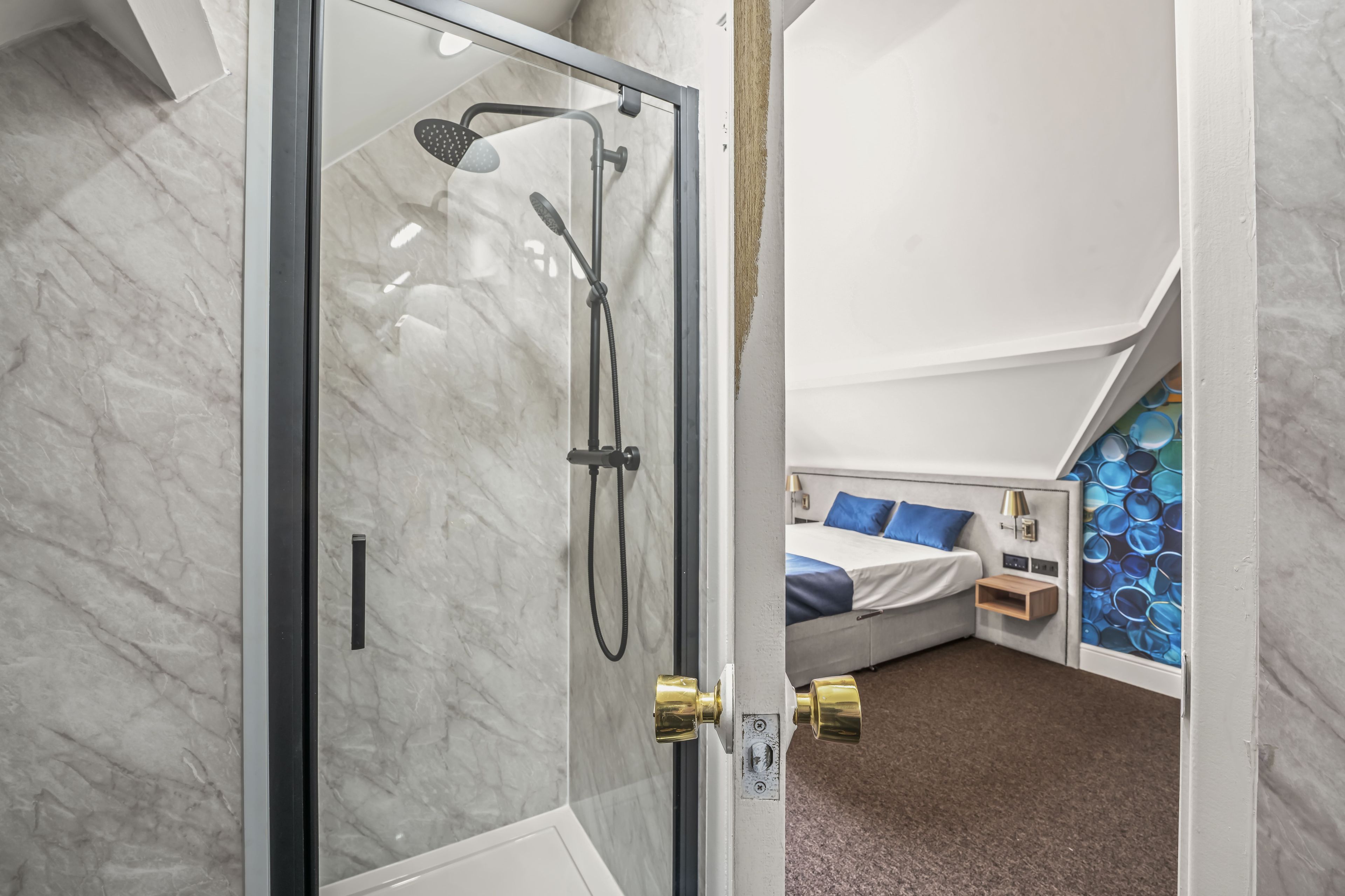 Un baño moderno con cabina de ducha de vidrio, inodoro blanco y ducha.