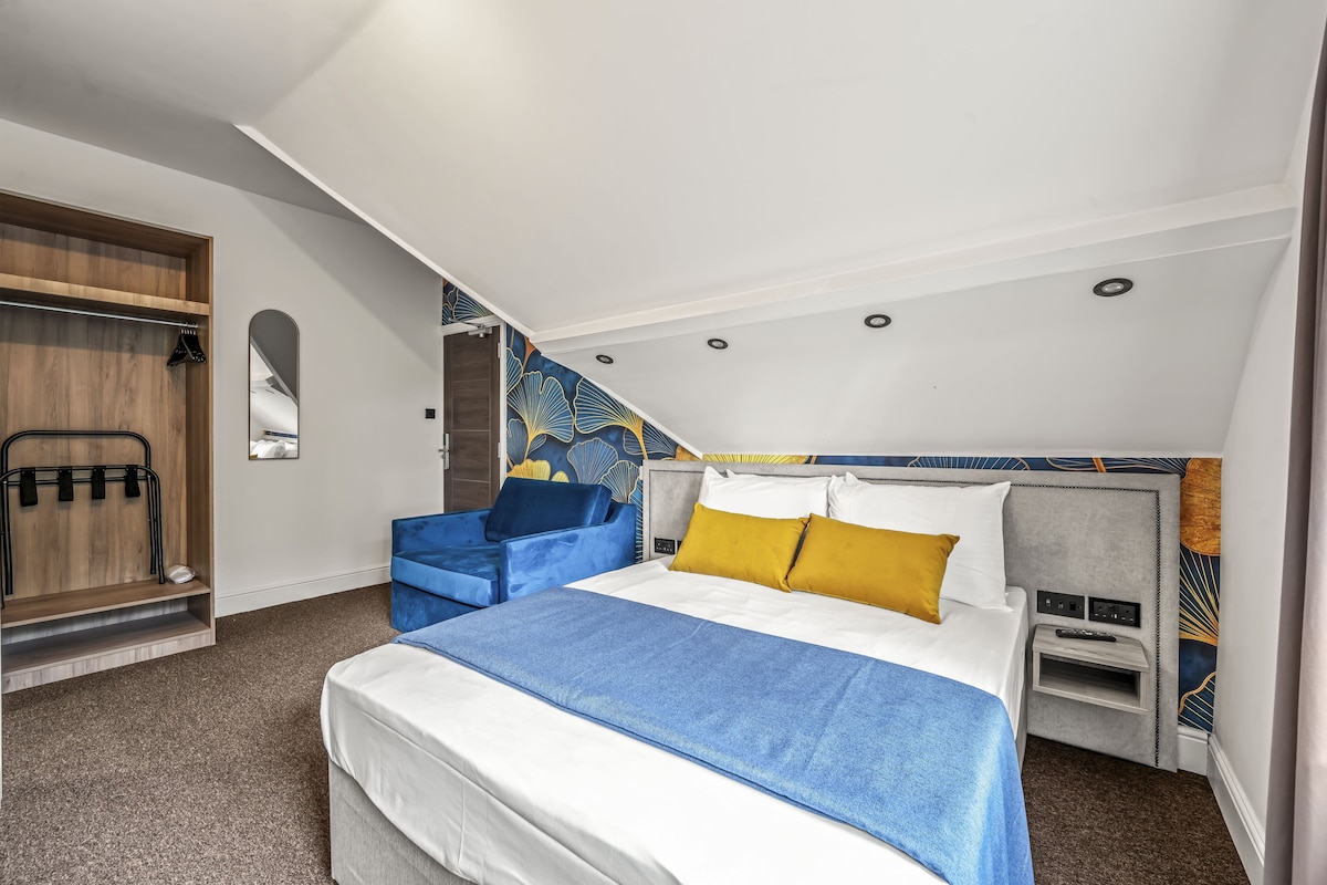 Una habitación de hotel moderna con cama, zona de estar y armario.
