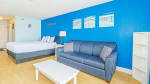 Een kamer met een bed, een bank, een bijzettafeltje en een muur met drie ingekaderde foto's.