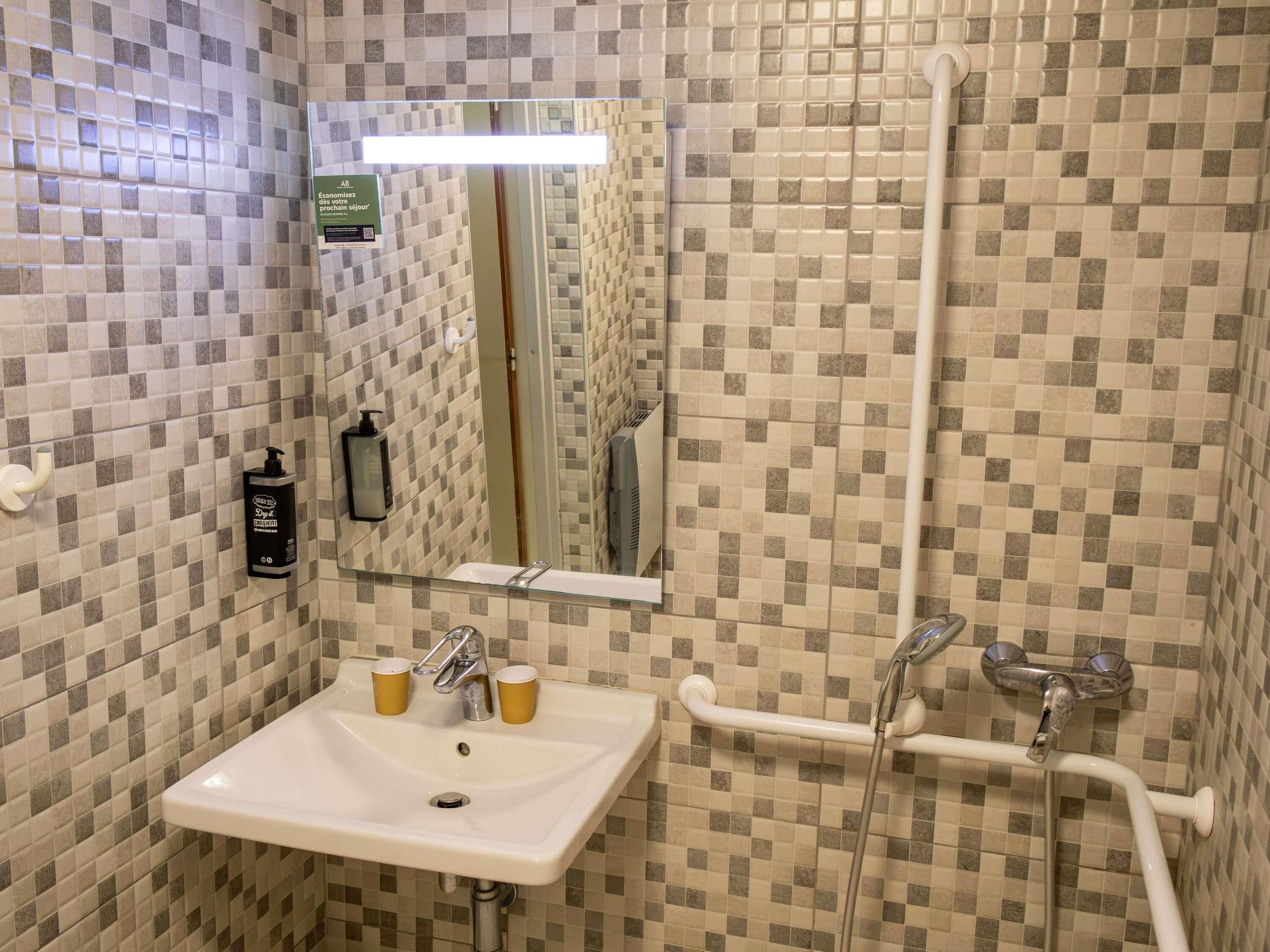 Un bagno con lavandino, specchio e doccia.