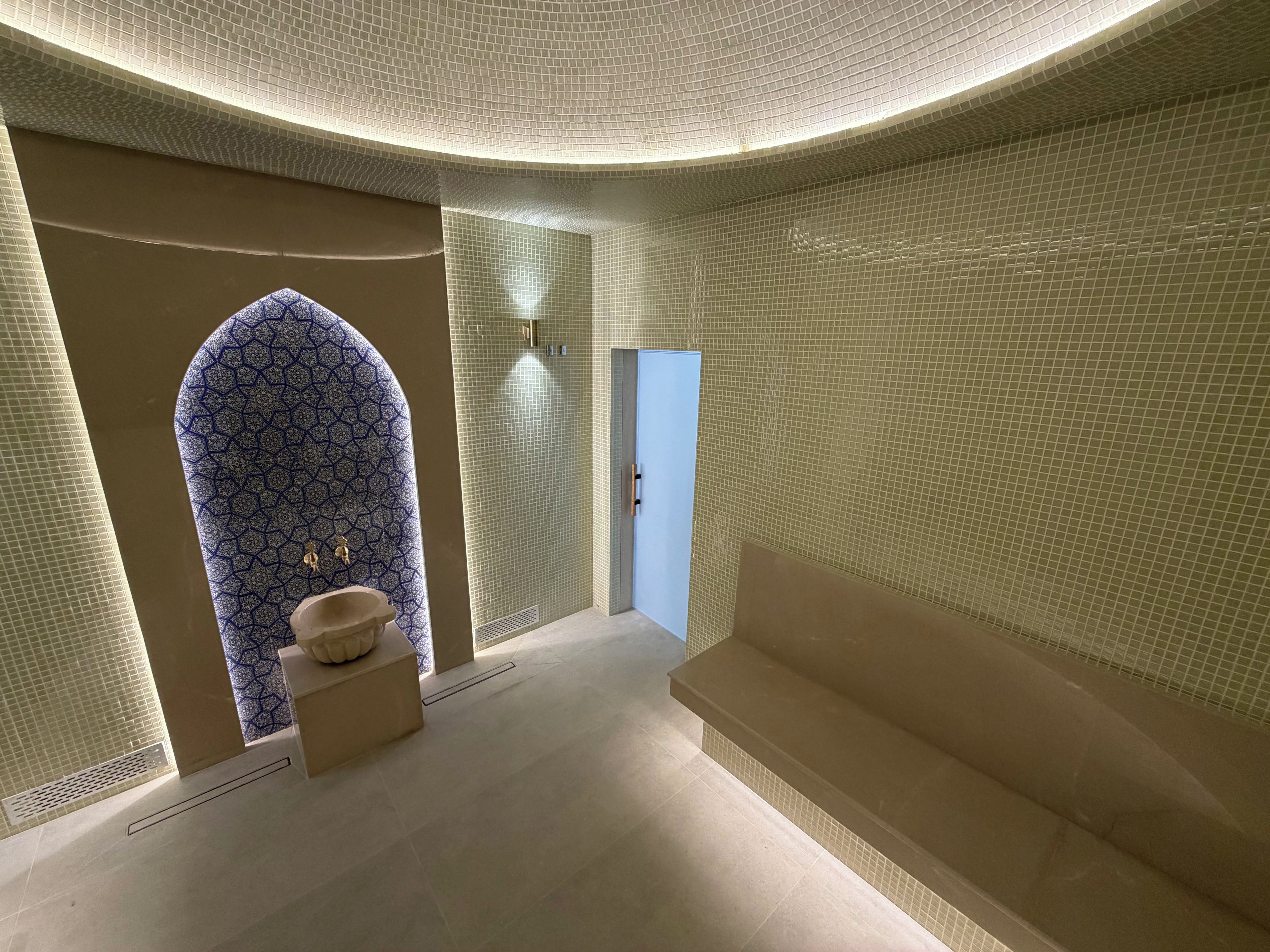 Une salle de bain avec un mur à motifs, un lavabo et une porte.