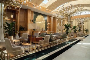 A luxurious lobby with a swimming pool, seating areas, and decorative lighting. - Mercure Khiva (Khiva)