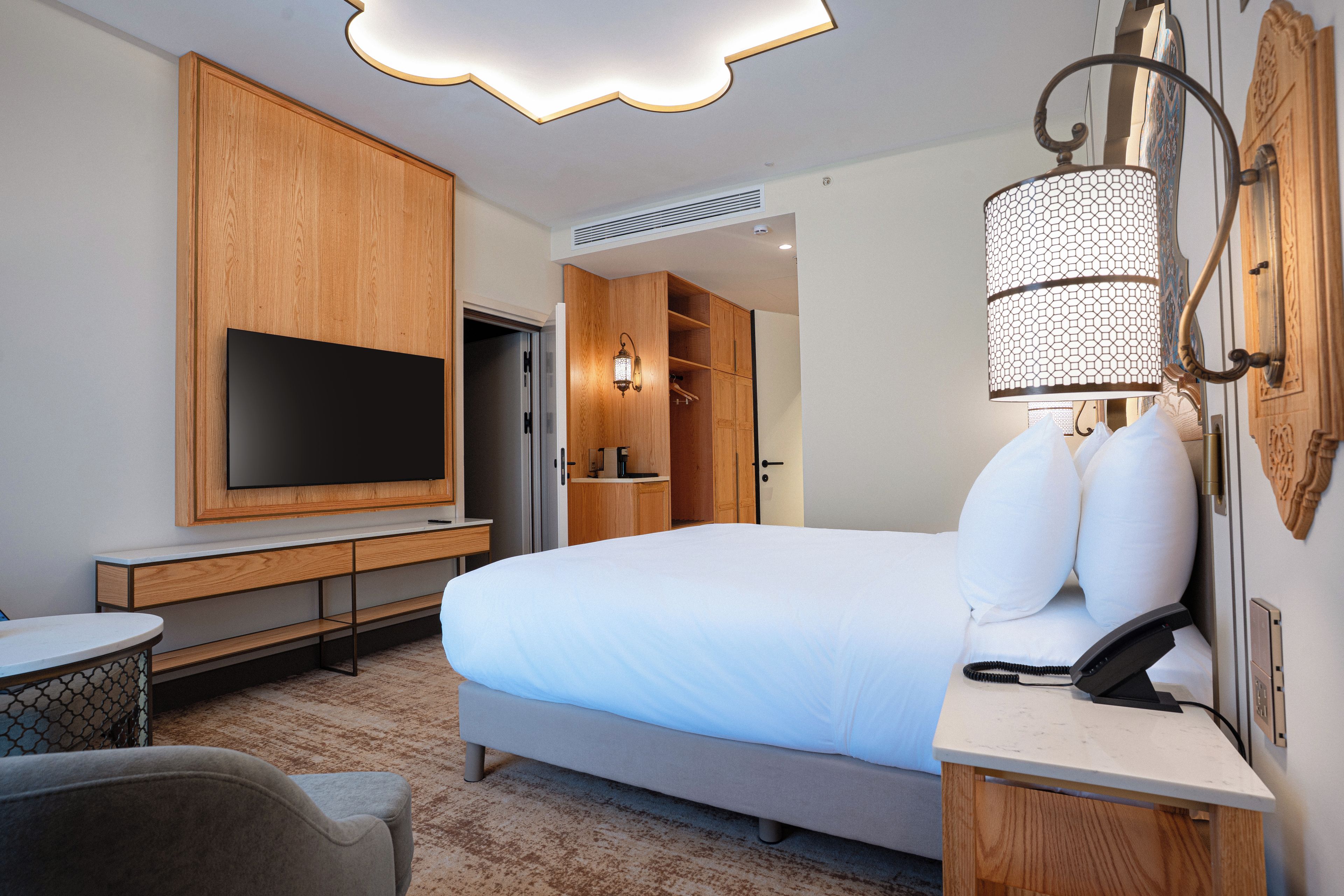 Une chambre d’hôtel avec un lit, une télévision, un bureau et une chaise.