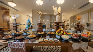A buffet with various food items and a decorative centerpiece.