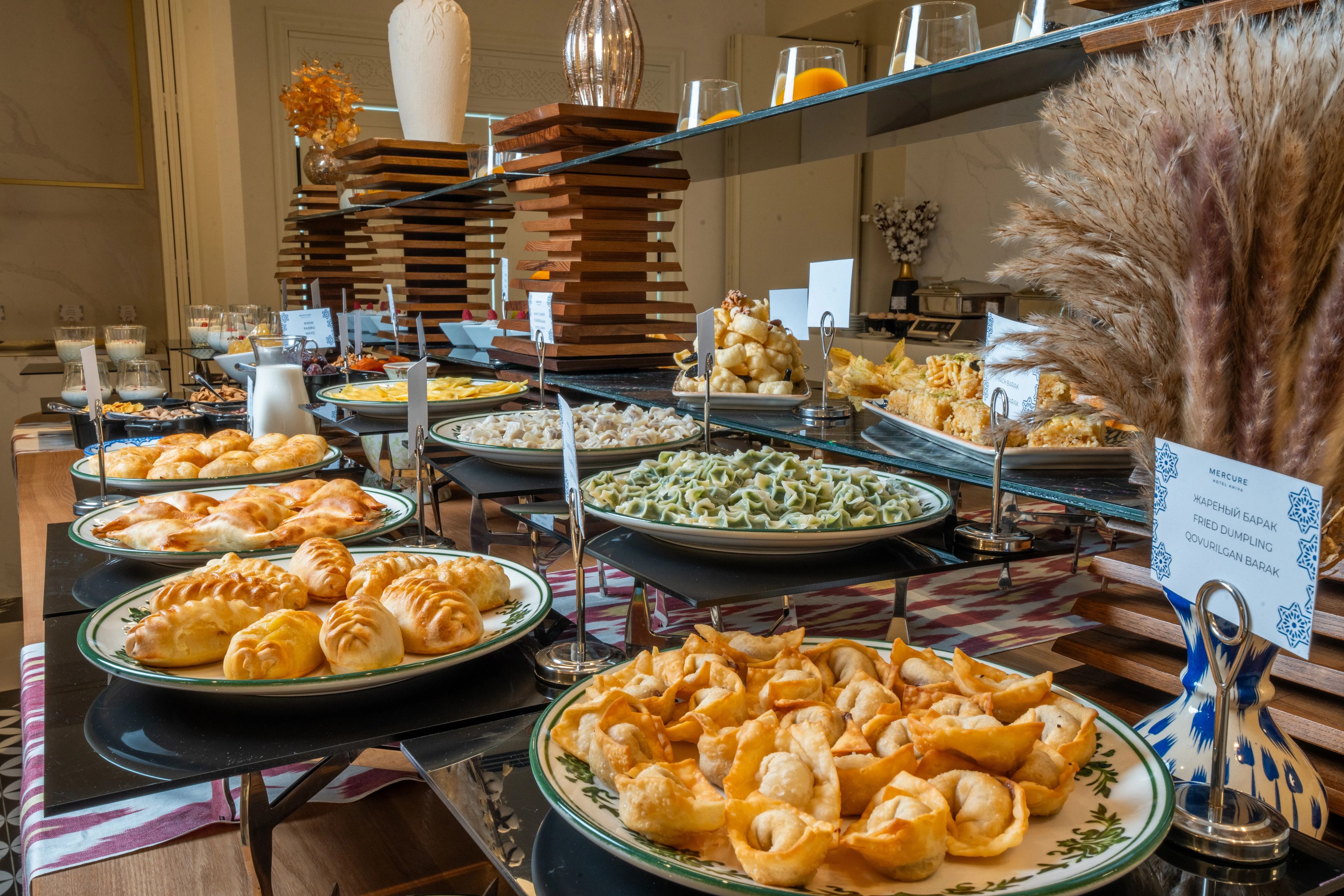 Een buffet met diverse gerechten, waaronder gebakjes en een ruime keuze aan maaltijden.