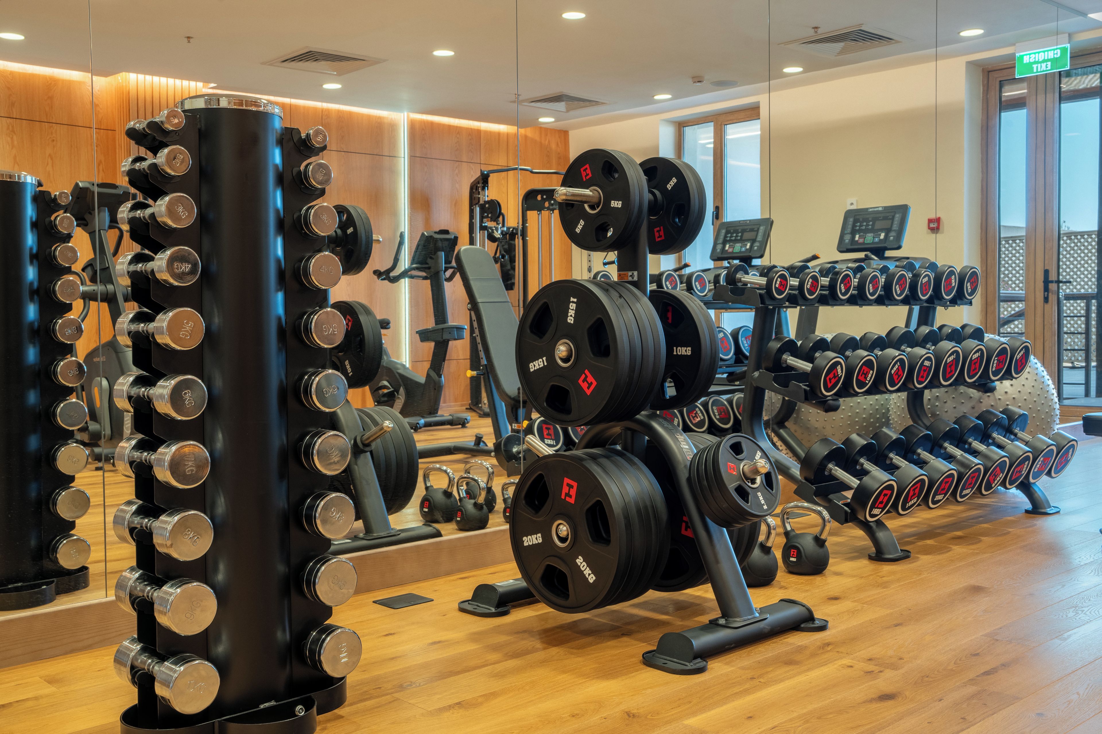 A gym with various weightlifting equipment, including dumbbells and barbells.