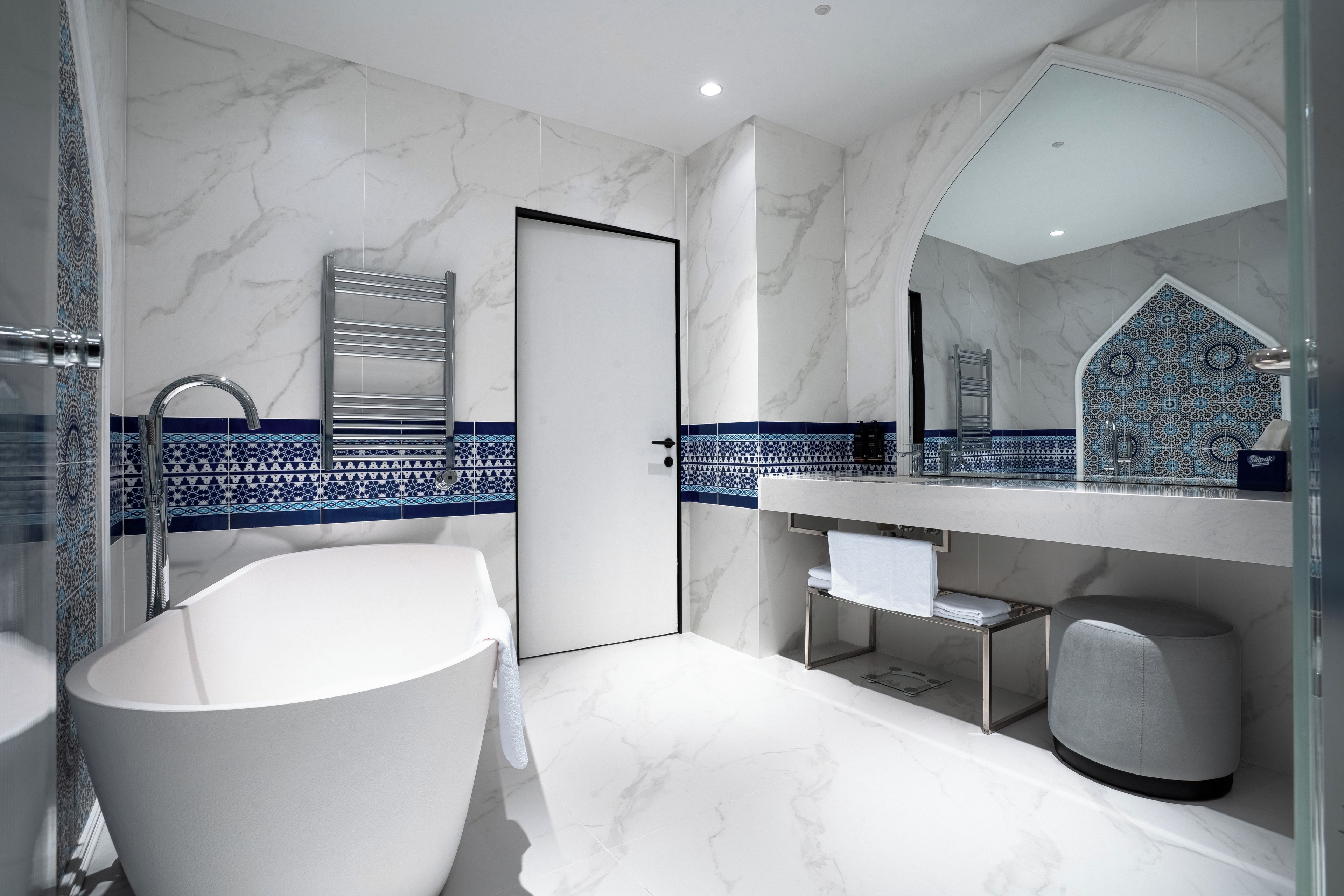 Un baño moderno con bañera, lavamanos y espejo.