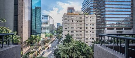A cityscape with modern buildings, a busy street, and a clear sky.